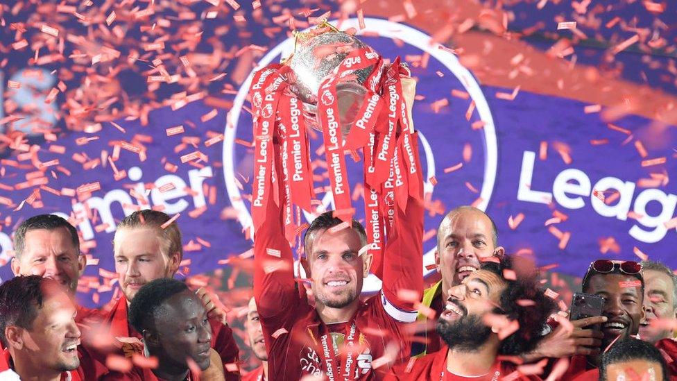 The Liverpool team lift the Premier League trophy