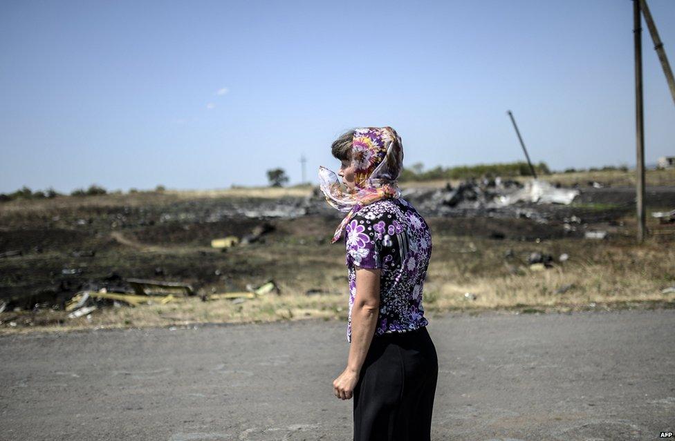 A woman looks at the crash site of the Malaysia Airlines Flight MH17 near the village of Hrabove (Grabovo), some 80km east of Donetsk, on August 2, 2014.