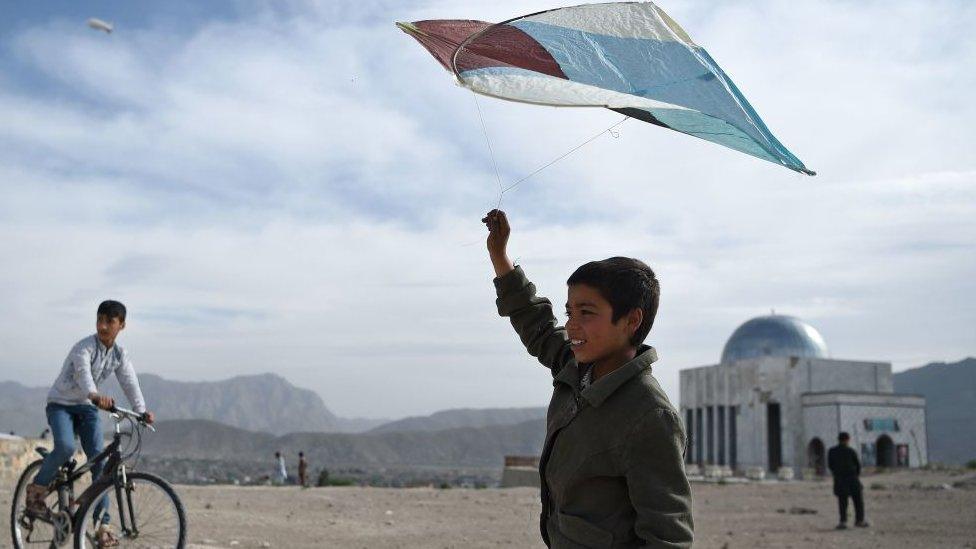 An Afghan boy prepares to fly a kite