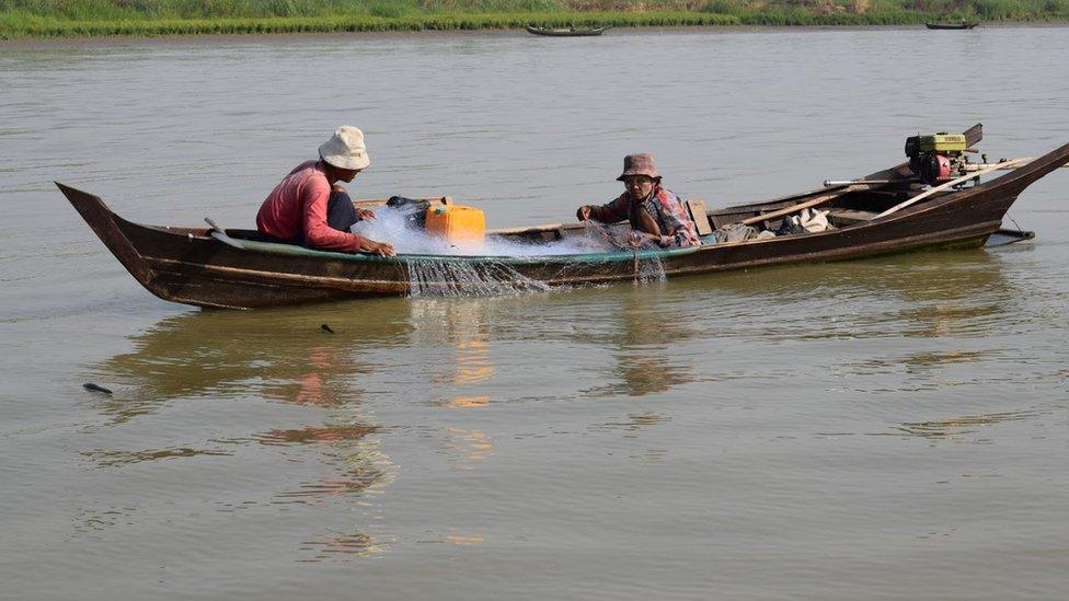 A man and a woman fish for hilsa