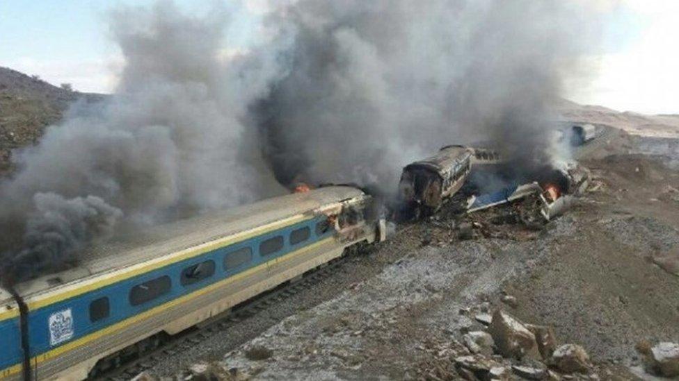 Smoke billows from destroyed train coaches at the site of a train accident in the city of Semnan, central Iran, 25 November 2016.