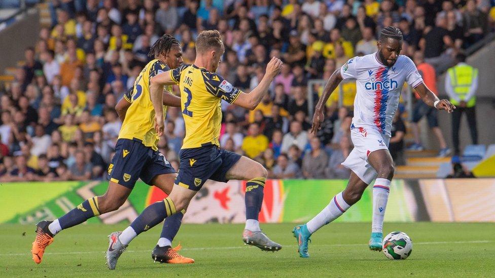 Oxford United players chasing Crystal Palace's Odsonne Edouard