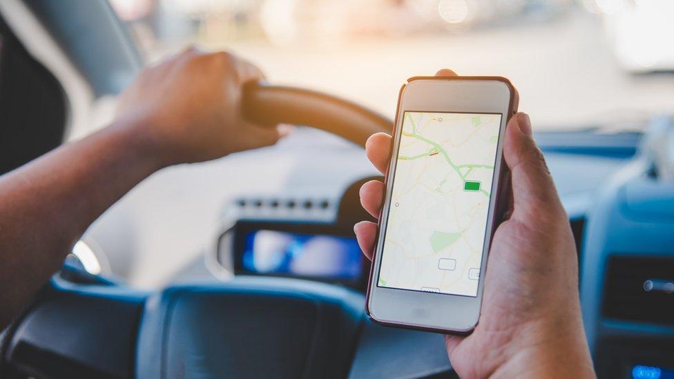 person-holding-phone-in-car