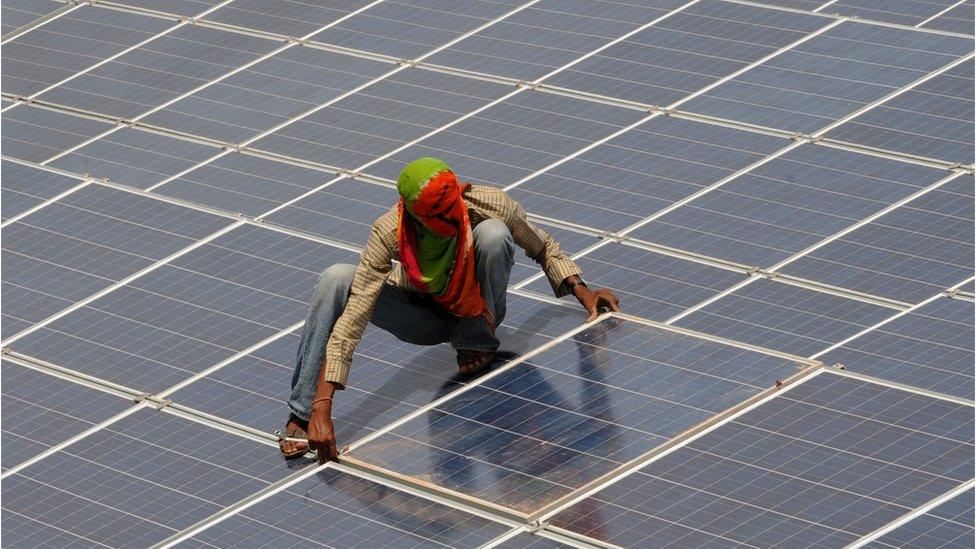 An Indian worker gives the finishing touches to solar panels at the Gujarat solar park at Charanka village of Patan district, some 250 kms from Ahmedabad on April 14, 2012.