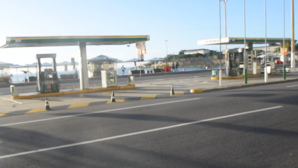 A gas station with no gas. There are no cars or people, and cones block the way in.