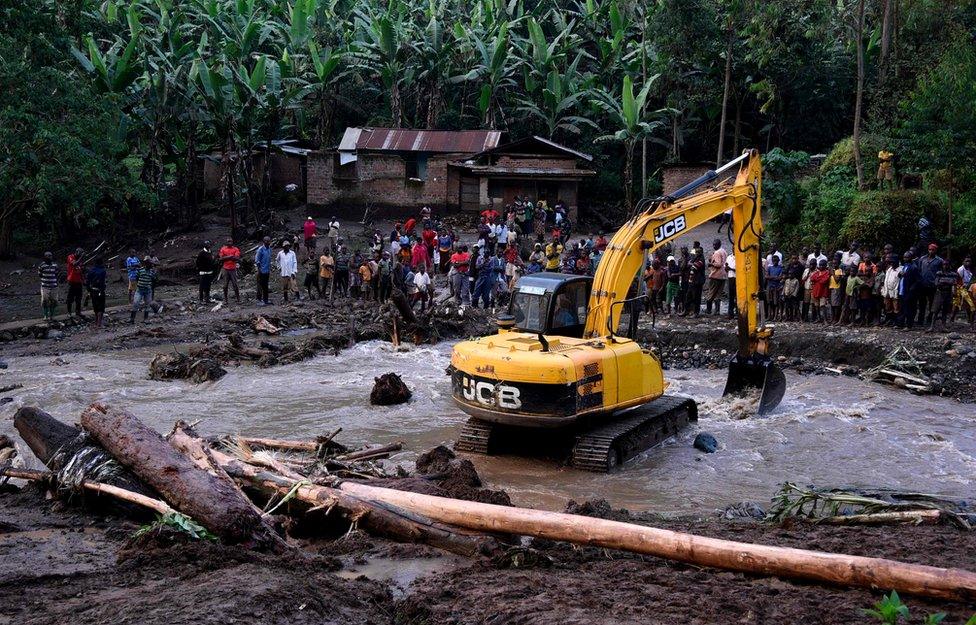 An excavator removes debris from the banks of the Sume river on October 12, 2018, after it burst its banks in the eastern village of Nanyinza, in Uganda"s Bududa district. - At least 34 people were killed after the river in eastern Uganda burst its banks, sending thick sludge and rocks barrelling into homes, disaster officials said