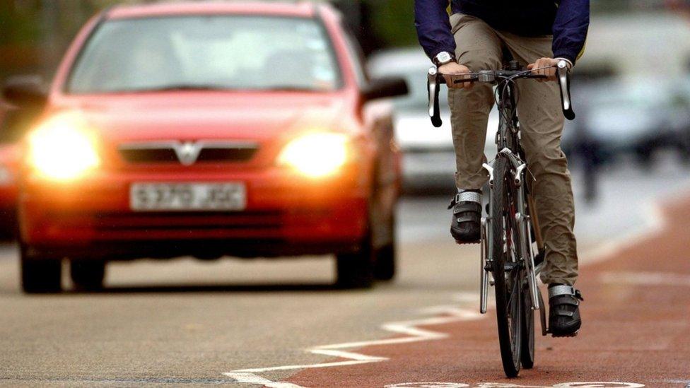 A cyclist using a cycle lane (bicycle, bike) alongside heavy traffic in Cambridge