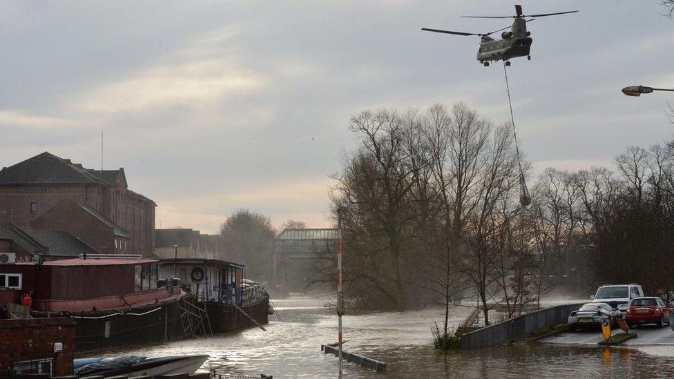 An army chinook helicopter airlifts equipment needed to repair the Foss Barrier on the River Foss