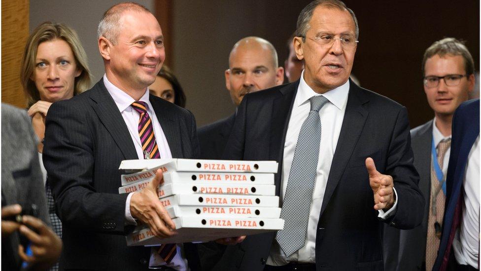 Russian Foreign Minister Sergei Lavrov (right) enters the press conference room with pizzas for waiting journalists from the US state department , 9 September, 2016