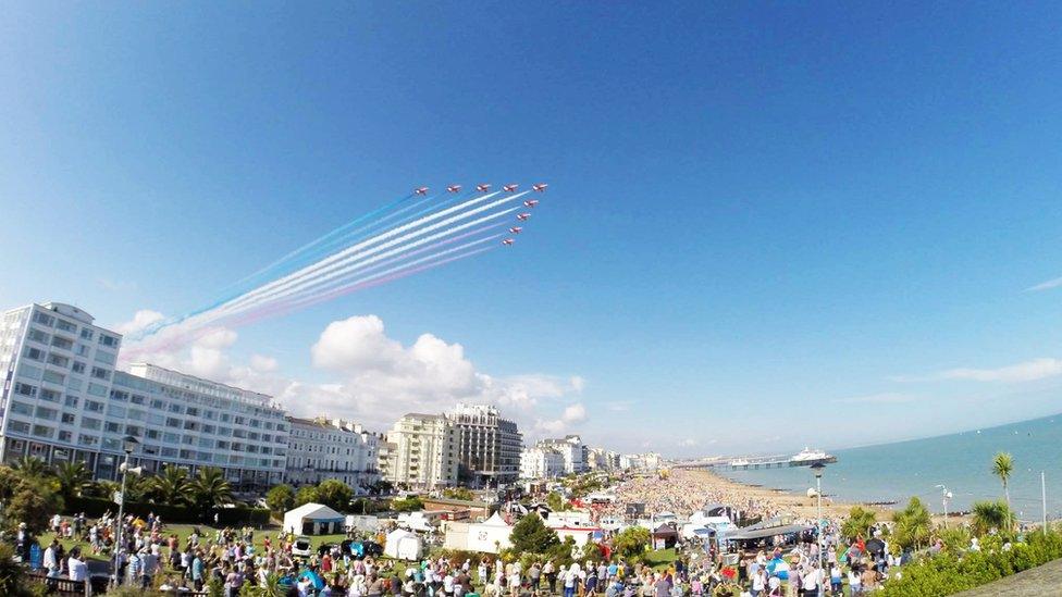 The Red Arrows in the sky as the crowd watches on