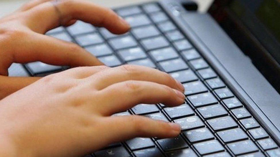 Fingers typing on a laptop