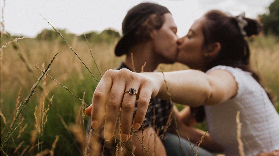 Hannah kisses her fiance while showing her engagement ring to the camera