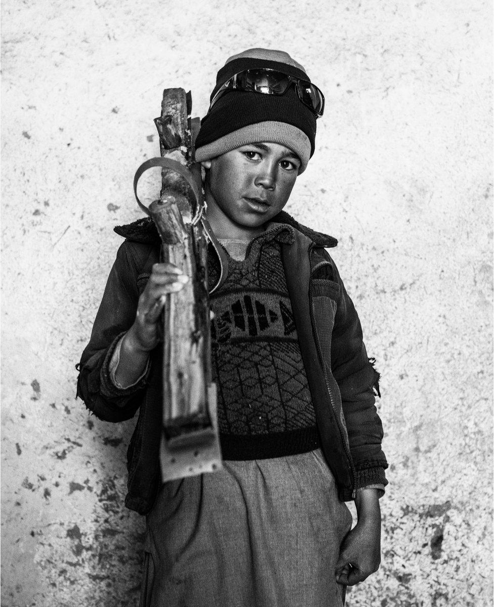 Nine-year-old Atiqullah poses with his skis in the village mosque of Aub Bala in Afghanistan