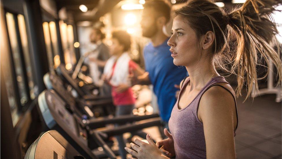 Group of young athletes running on treadmills.