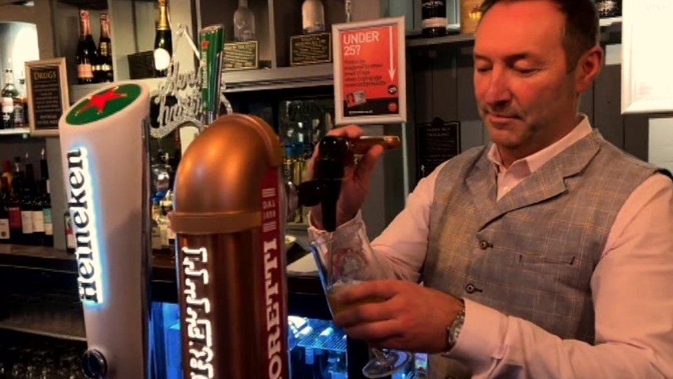 Les Langley pours a pint of beer behind the bar