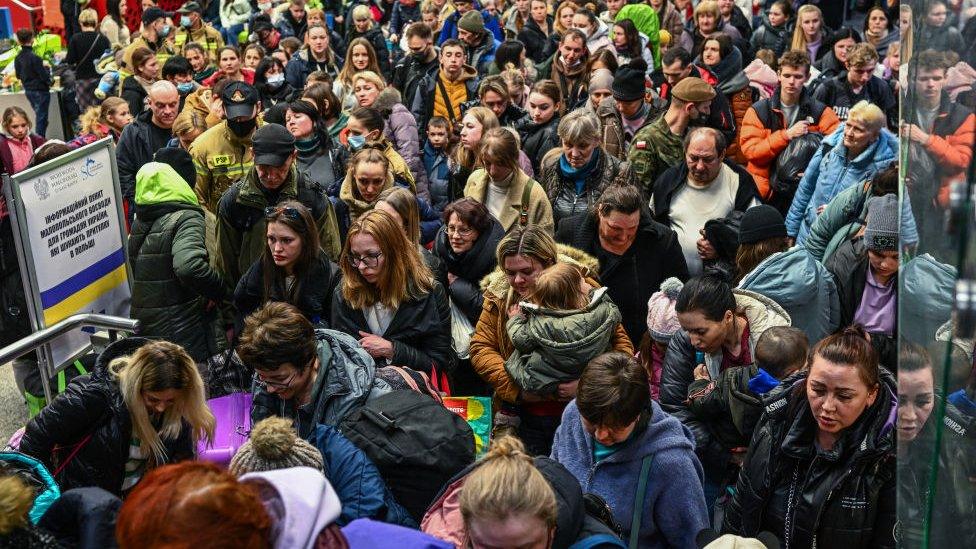 Group of Ukrainian refugees packed into train station