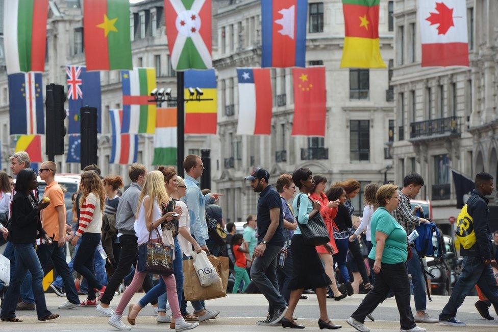 People crossing Regent Street, decked out with flags