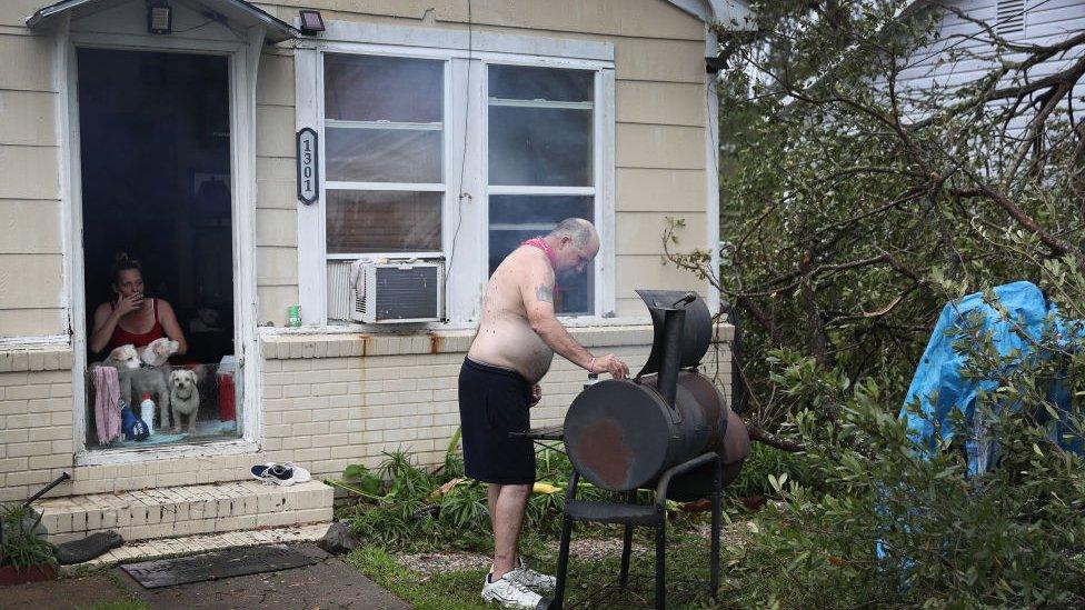 David Veillon cooks food that was left in his refrigerator before it goes bad after Hurricane Laura passed through the area on August 28, 2020 in Lake Charles, Louisiana