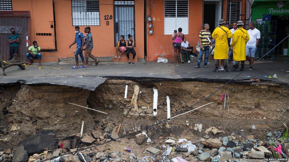 People look over a collapsed road