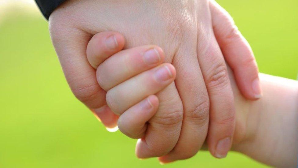 Adult and child holding hands (generic)