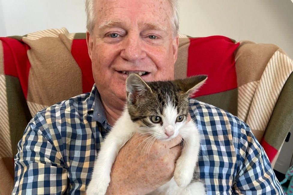 A man holds a kitten