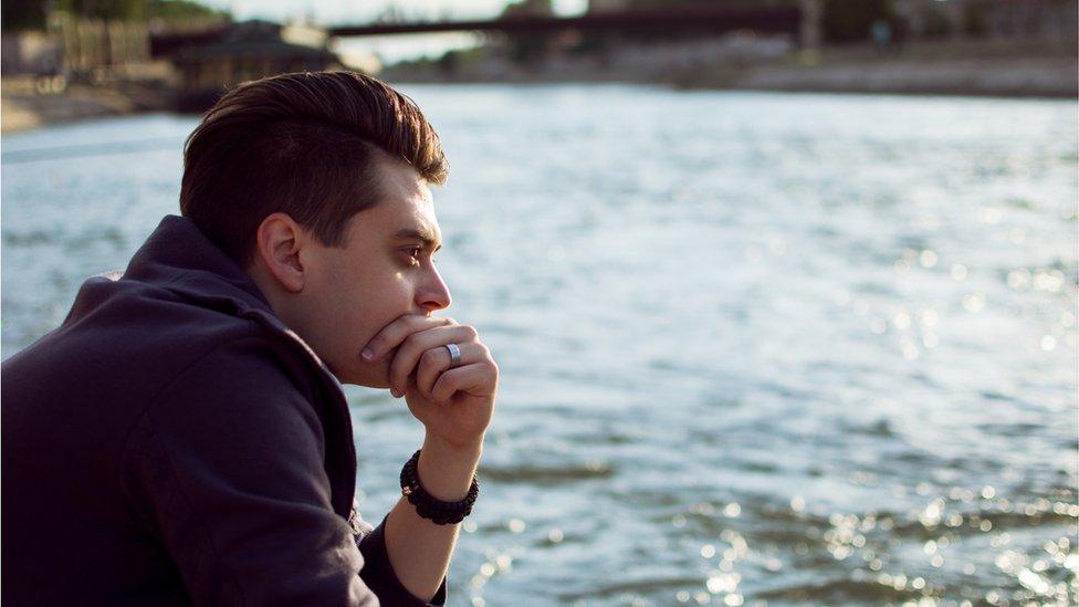 Young man gazing at a river