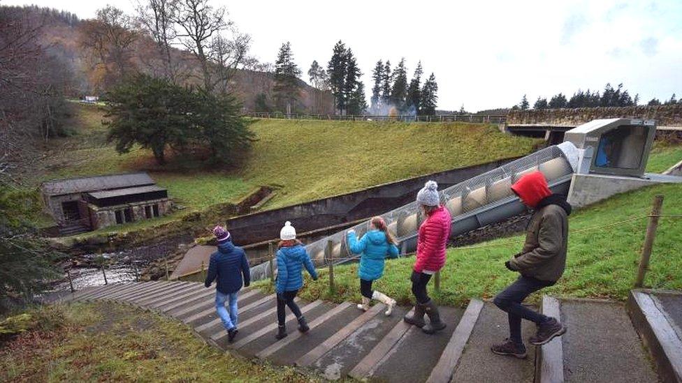 Visitors by the Archimedes screw hydro-electric turbine at Cragside, Northumberland