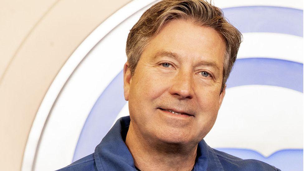 A picture of John Torode in a blue shirt
