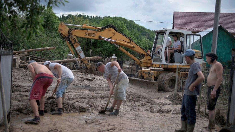 Men clear the streets in the Ukrainian village of Lanchyn