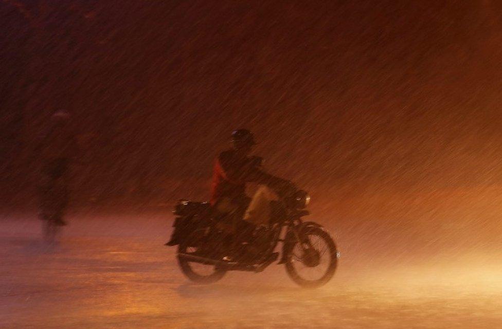 A scooter driver caught up with a heavy rain in Bangalore, India, 01 June 2016.