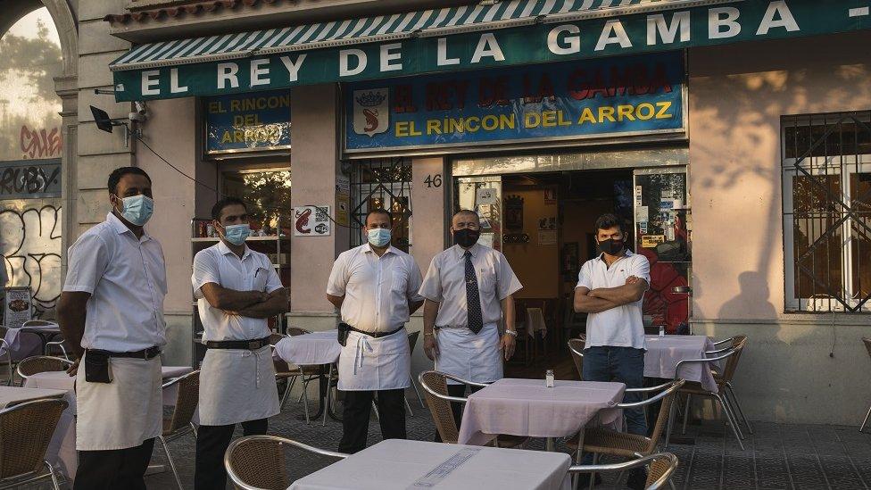 The staff of El Rey de la Gamba 2 restaurant poses for photos outside their restaurant on July 27, 2020 in Barcelona, Spain