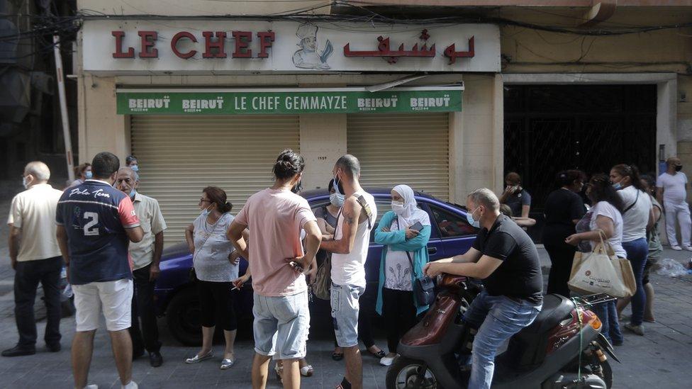 People stand outside the shuttered Le Chef restaurant on 13 August 2020