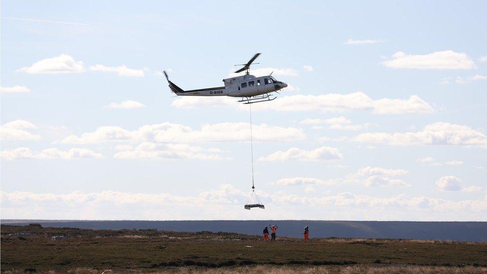 A helicopter delivering concrete blocks at the transmitter site