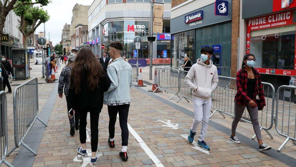 Members of the public walk through the city centre which has been marked out with social distancing markings on July 04, 2020 in Wolverhampton, England