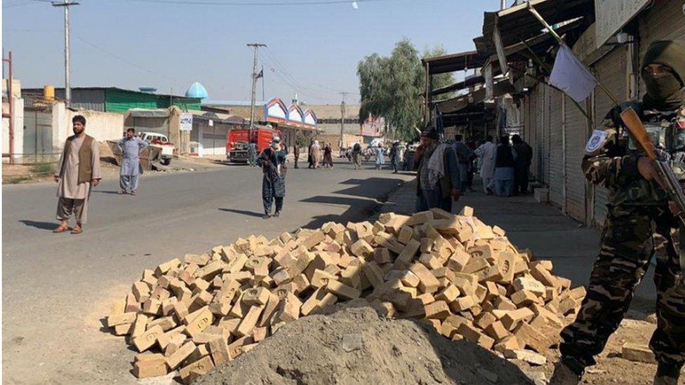 Taliban soldiers guard the road to the mosque