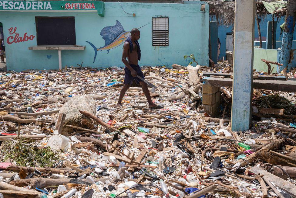 A man wearing shorts walks along the beach of Manresa, covered with debris, following the passage of Hurricane Beryl, in Santo Domingo, Dominican Republic, 3 July 2024.