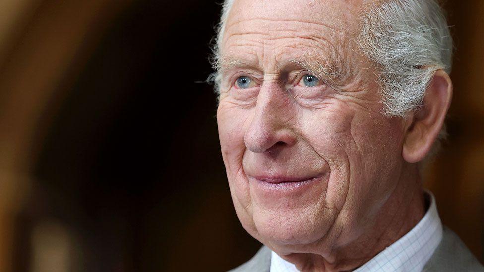 King Charles III smiles