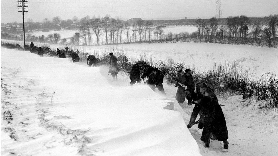 Men shovelling deep snow