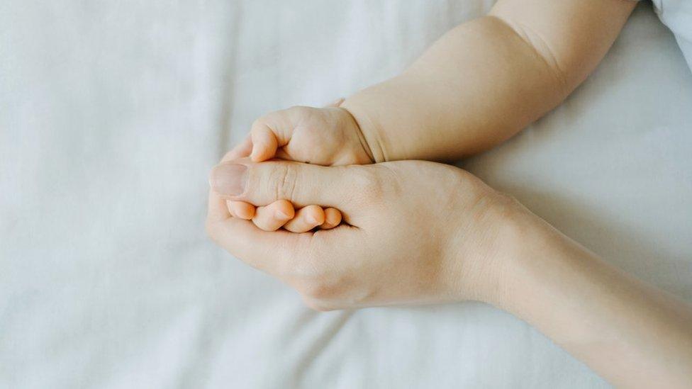 Woman's hand hold baby's hand