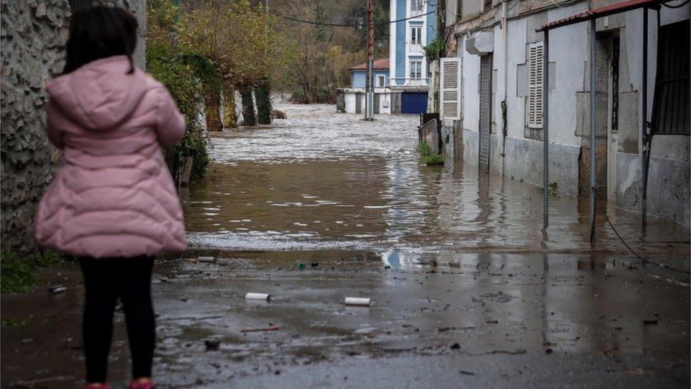 A child looks at a flooded street after river Deba overflew in Mendaro, Basque Country, Spain, 10 December 2021