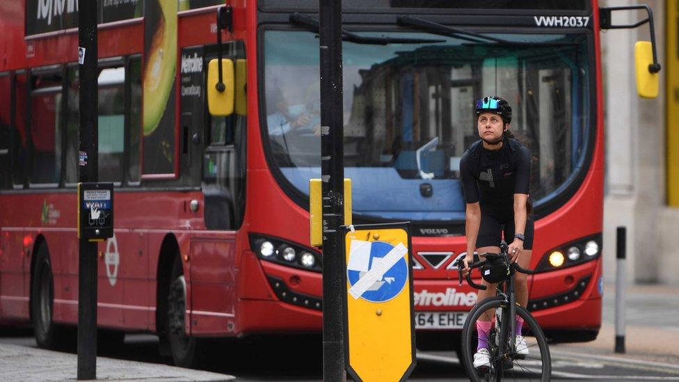 cyclist in front of bus.