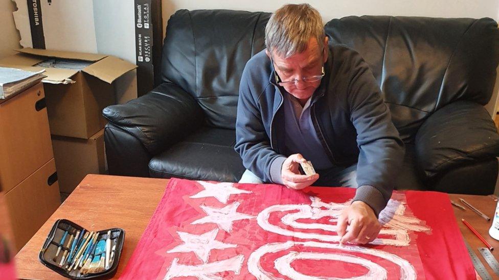 Peter Carney creating a banner