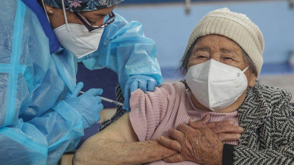 A woman is given a dose of vaccine in Cuenca