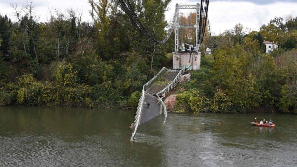 Rescuers sail near a suspension bridge which collapsed on 18 November in Mirepoix-sur-Tarn, near Toulouse, southwest France