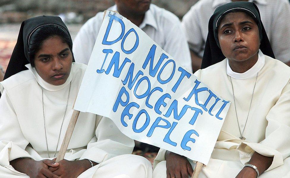 Indian Christian nuns hold a placard as they listen to a speaker during a rally in New Delhi on October 1, 2008 in Karnataka