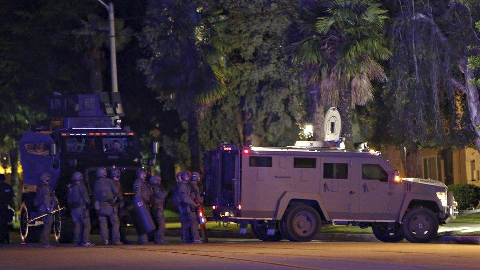 Police officers and their vehicles line the street outside the house of one of the suspects in a mass shooting in Redlands, California December 2, 2015.