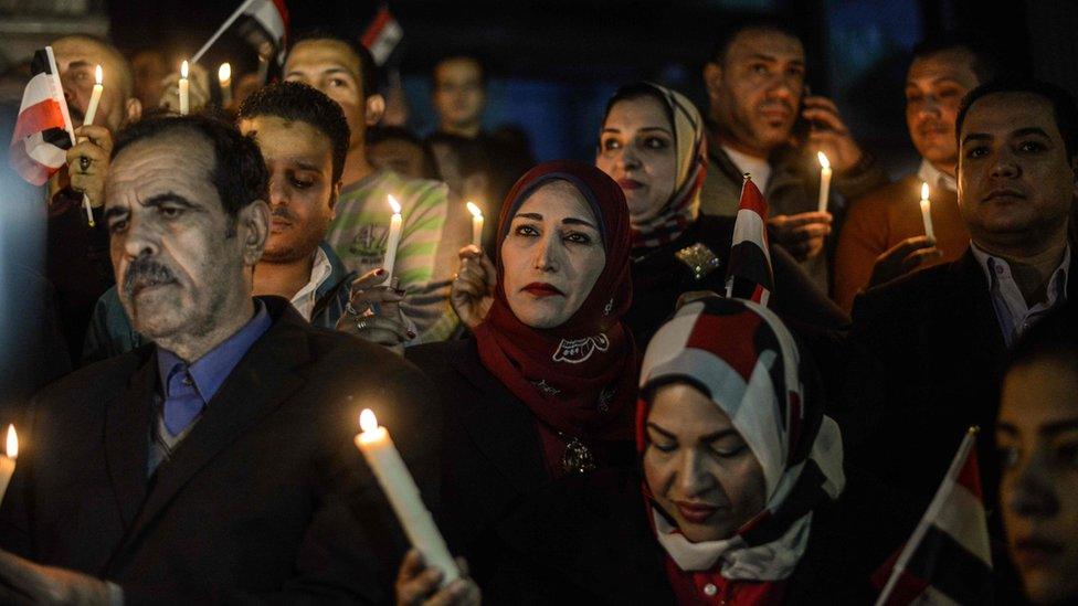 Egyptians hold candles at a vigil outside the Syndicate of Journalists in Cairo on 27 November 2017