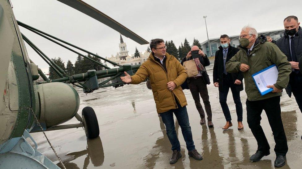 Ukrainian Foreign Affairs Minister Dmytro Kuleba (L) inviting to a helicopter Josep Borrell (2nd R) at Kharkiv International Airport on 5 January