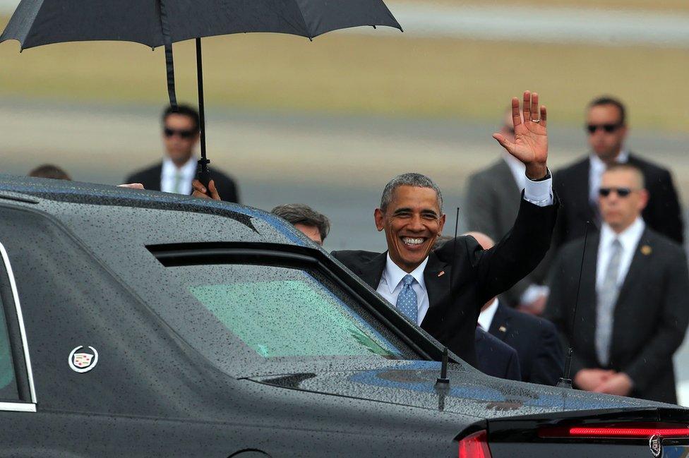 President Barack Obama (centre) waves as he gets in his limousine