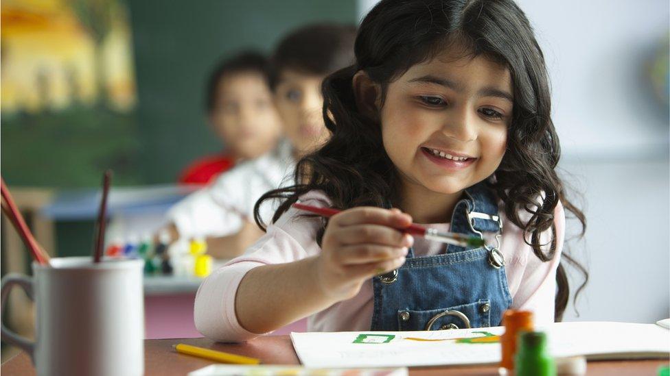 Schoolgirl painting in classroom